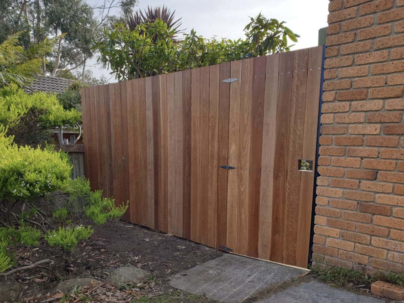Hardwood paling screen and gate in a black steel frame
